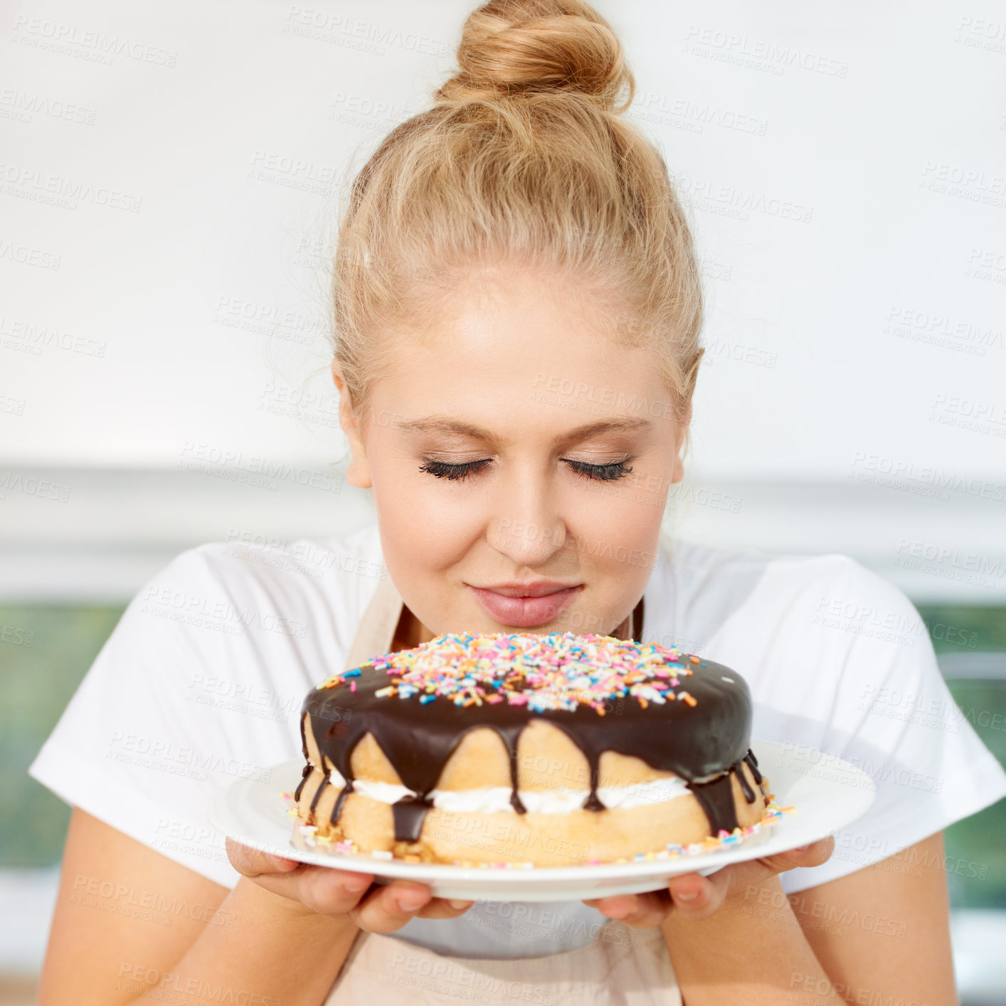 Buy stock photo Smelling, cake and girl is holding dessert for celebration with chocolate and sprinkles with scent at a bakery. Female baker, birthday and food with pastry for party or eating a sweet meal with cream