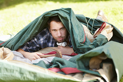 Buy stock photo Nature, camping and portrait of man in a tent in the outdoor woods or forest in Canada. Serious, adventure and young male person with hammer in canopy for shelter on holiday, vacation or weekend trip