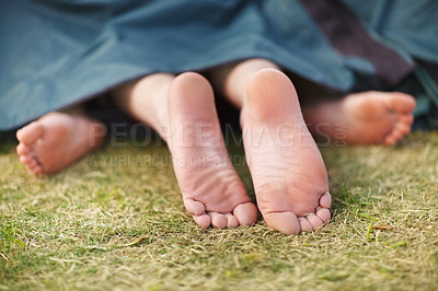 Buy stock photo Camping, couple and feet on the grass outdoor and sleeping with partner in nature on holiday or travel. Foot, legs and people relax together with blanket on ground or rest on adventure or vacation
