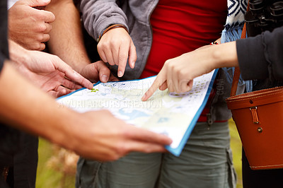 Buy stock photo Cropped view of a group of friends holding a map and looking for directions