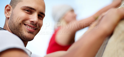 Buy stock photo Portrait of a young couple climbing a rock face together