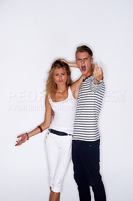 Buy stock photo Fashion, middle finger and portrait of couple on a white background with trendy clothes, style and outfit. Angry, upset and isolated man and woman in studio with confidence, attitude and emoji
