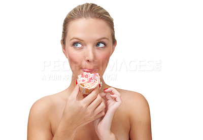 Buy stock photo A naughty looking blonde woman eating a cupcake