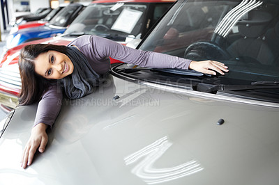 Buy stock photo Beautiful young woman leaning over and lying across the bonnet of a coveted car