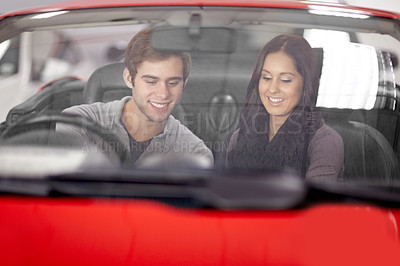 Buy stock photo Smile, dealership and couple talking in a car after a purchase together for romance. Smile, love and young man and woman from Canada buying new vehicle for relationship in showroom for transport.
