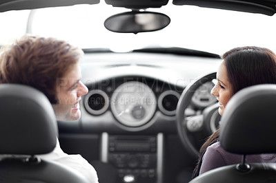 Buy stock photo Happy, driving and couple talking in a car at a dealership for transportation purchase together. Smile, love and young man and woman from Canada in discussion for buying a new vehicle at a showroom.