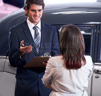 Buy stock photo Car dealership, woman and man with agreement for deal, sale and writing for payment with smile. Girl, paperwork and happy for signature with legal contract, loan and compliance for vintage vehicle