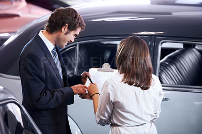 Buy stock photo Car dealership, woman and man with paperwork to sign, sales and writing for payment with deal. Girl, agreement and back with signature with legal contract, bank loan and checklist for vintage vehicle