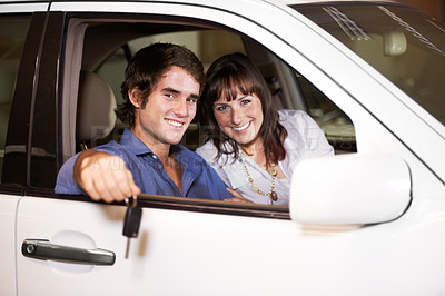 Buy stock photo Smiling young couple seated in their new car and holding the keys