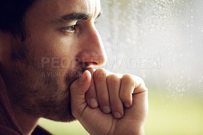 Buy stock photo A young looking pensive while covering his mouth with a clenched hand