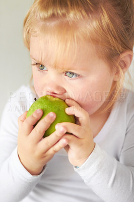 Buy stock photo Baby, hungry girl and eating apple with thinking, learning and nutrition for growth in childhood at family home. Infant child, toddler and biting green fruit for health, wellness and diet in house