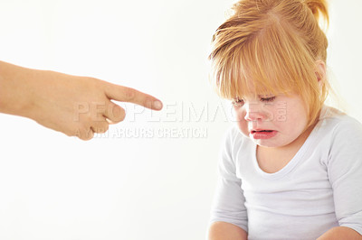 Buy stock photo A cute baby girl crying while her mother points at her
