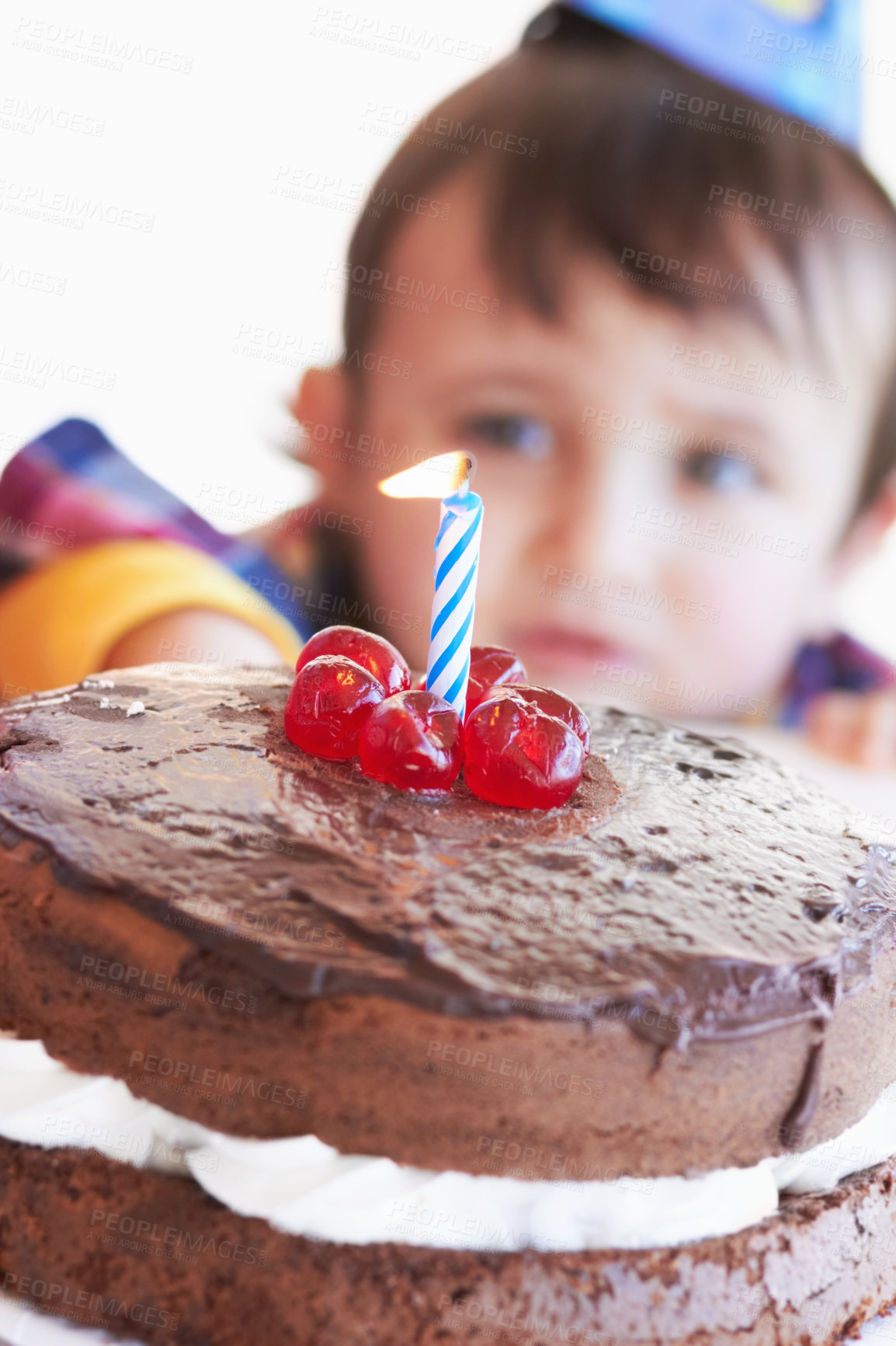 Buy stock photo A birthday cake with one candle with the birthday boy in the background