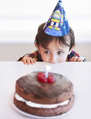 Buy stock photo A cute little boy looking at his birthday cake in anticipation