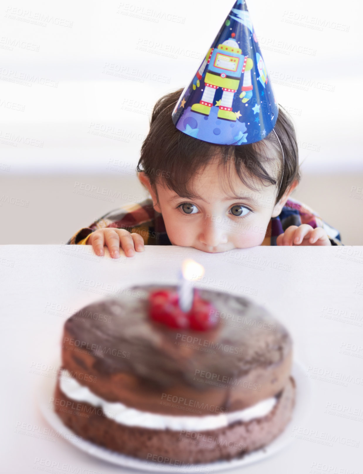 Buy stock photo A cute little boy looking at his birthday cake in anticipation