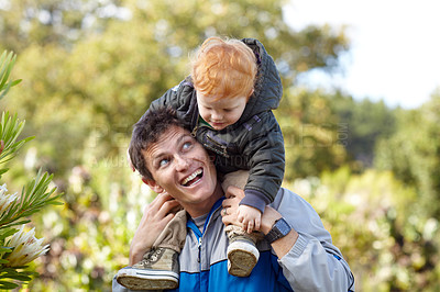 Buy stock photo A young father carrying his young son on his shoulders
