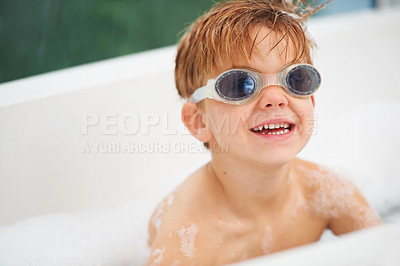 Buy stock photo Smile, bath and a boy in swimming goggles having fun while cleaning for natural hygiene in water. Children, soap and bubbles with a happy young kid alone in the bathroom to wash for fresh skincare