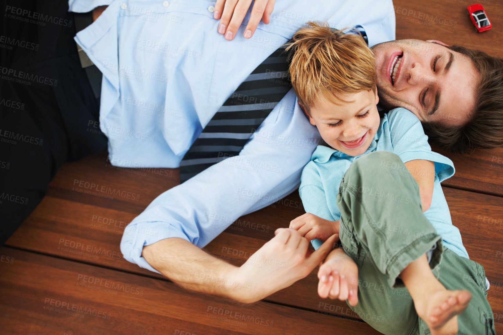 Buy stock photo Father, child and playing on floor with happy, family home and support of businessman with kid. Man, kid and game in freedom together to relax, trust and love in room with care, house and wellness
