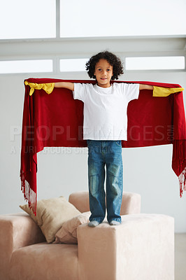 Buy stock photo Portrait, children and a boy superhero in a costume on a sofa in the living room of his home for playing a game. Creative, growth and fantasy with a young kid in a cape for justice or safety cosplay