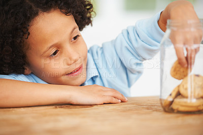 Buy stock photo A cute young boy grabbing a cookie from the cookie jar