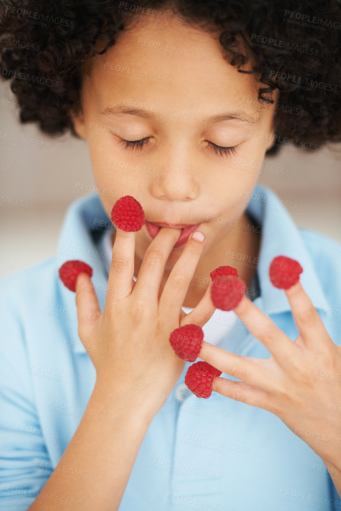 Buy stock photo A cute young boy eating raspberries off his fingers with his eyes closed