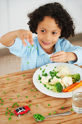 Buy stock photo A cute young boy throwing peas from his plate all over the table