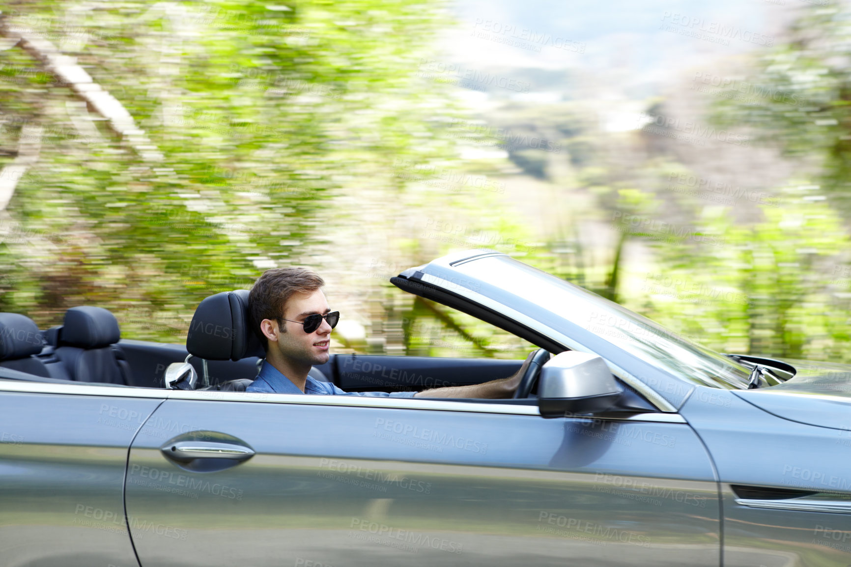 Buy stock photo A young male driving a silver convertable