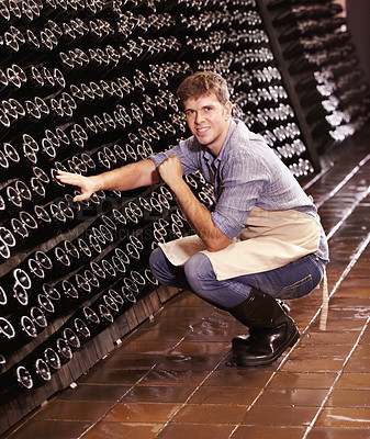 Buy stock photo Portrait, man and counting bottles of wine in cellar, warehouse or factory. Alcohol, manufacturing and male person count, happy inspection or quality control at production plant, winery or distillery