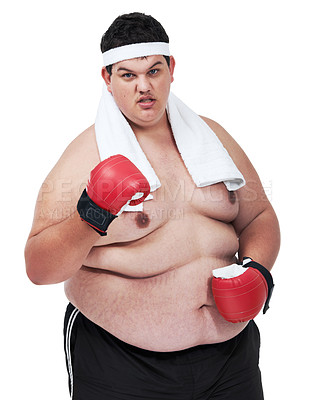 Buy stock photo A studio shot of an obese young man wearing boxing equipment and waving a fist at the camera
