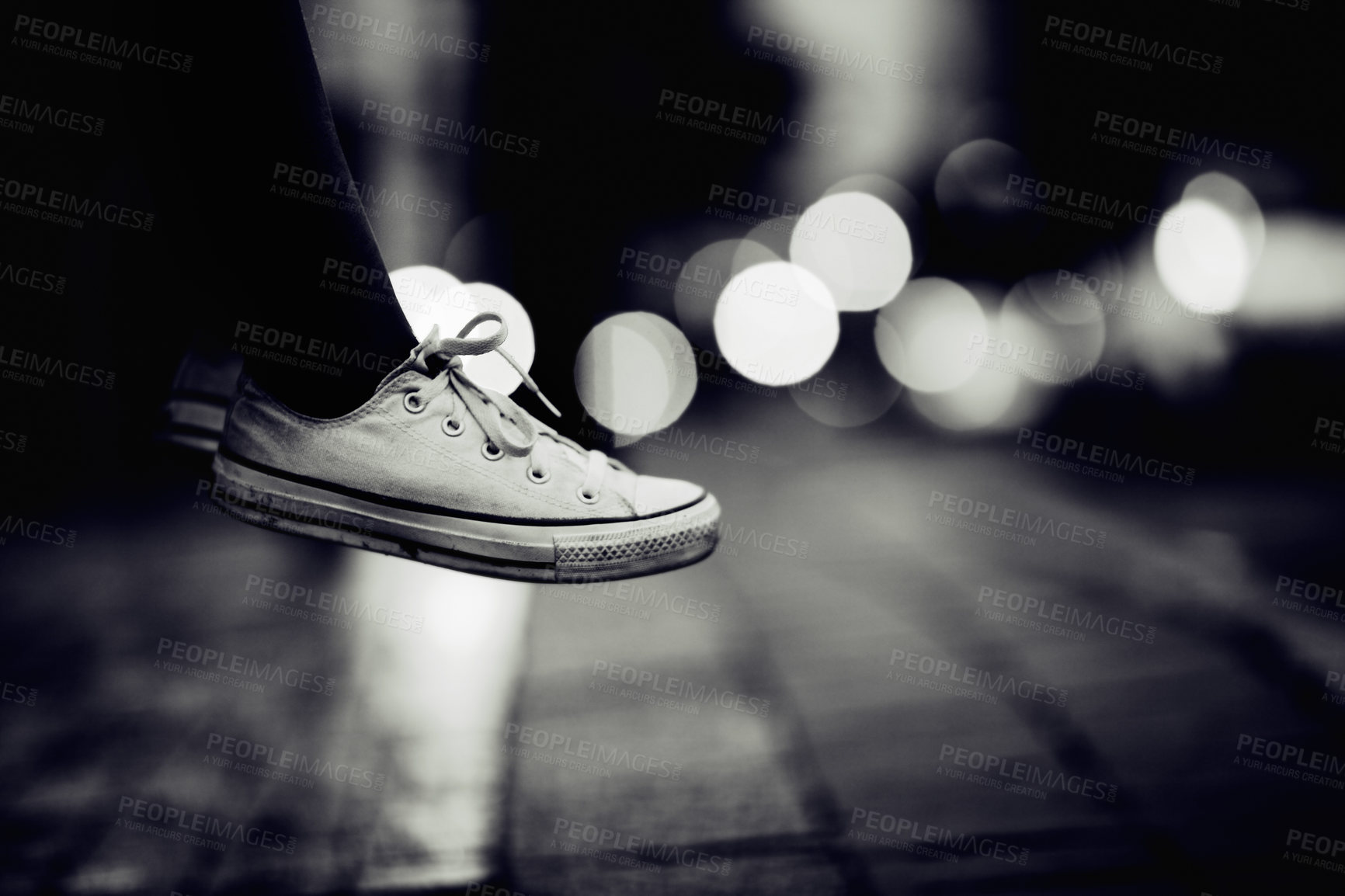 Buy stock photo Closeup, monochrome and sneakers outdoor, city and lights with creativity, road and artistic. Zoom, person or model with shoes, street and grey with footwear, night or creative with fashion or travel