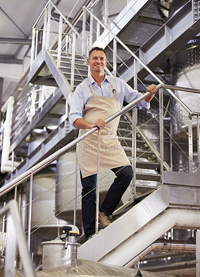 Buy stock photo Factory, portrait and male wine maker standing on the stairs in a production warehouse. Success, smile and full length of a man winery employee working in alcohol manufacturing cellar on a vineyard.