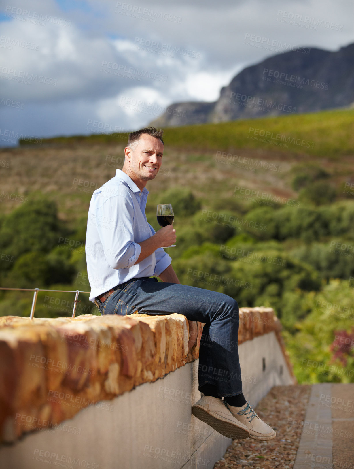 Buy stock photo Portrait, mature man with red wine and in vineyard or farm sitting on wall. Agriculture, beverages or drinks with glass and happy male sommelier or farmer with champagne or alcohol outdoors 