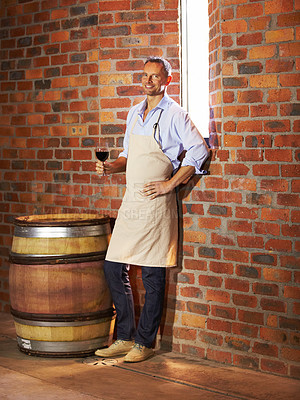 Buy stock photo Portrait, man sommelier with glass and taste in cellar or factory. Alcohol or drink, production storage or industry and happy mature male smile and standing by wooden barrel during wine tasting