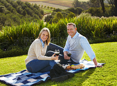 Buy stock photo Portrait of a loving mature couple enjoying a picnic on the grass