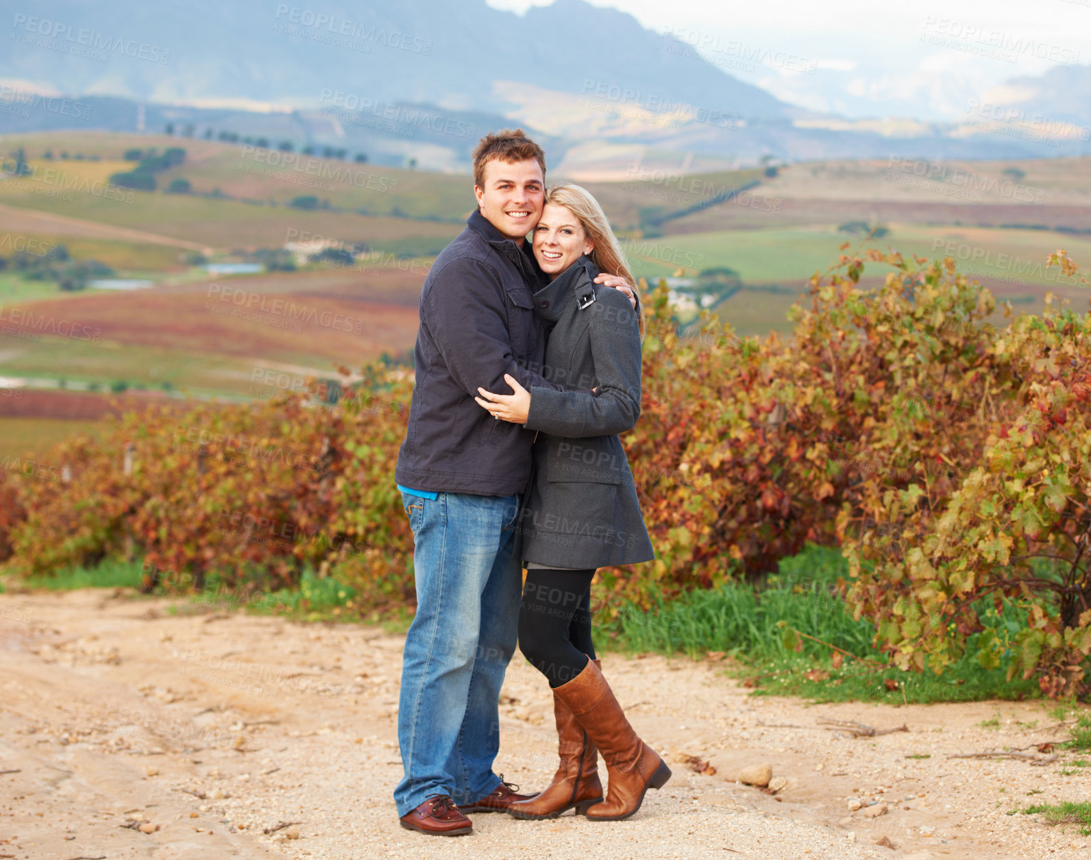 Buy stock photo Portrait of a young couple standing together in the vineyards