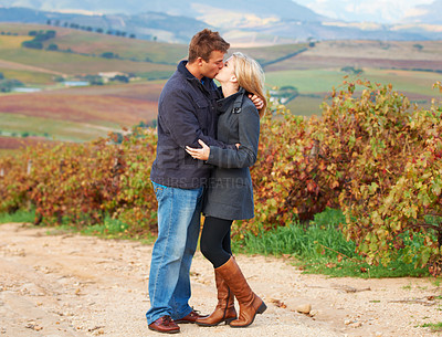 Buy stock photo Love, romance and couple kissing in a vineyard outdoor while on a date in celebration of their relationship. Romantic, dating or kiss with a man and woman on a farm for agriculture or sustainability