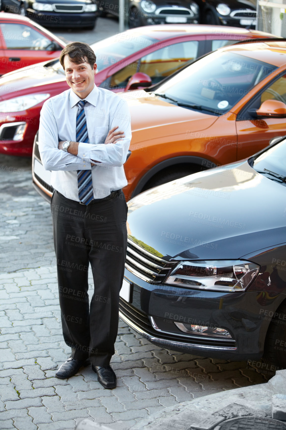 Buy stock photo Portrait, smile and a man arms crossed in a parking lot for car sale at a commercial dealership. Business, luxury and automobile trade with a happy young salesman outdoor for transport rental