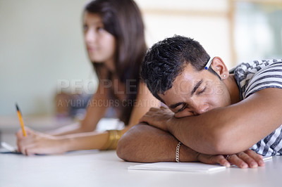 Buy stock photo Tired, sleeping and a bored man in a classroom for learning, education and university burnout. Mental health, campus and a male student at a desk for rest, stress or fatigue in a college lecture