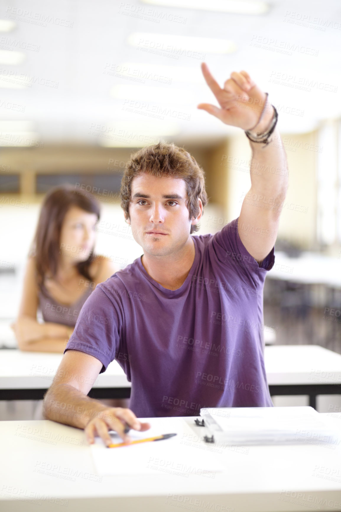 Buy stock photo A young caucasian man raising his hand in class to ask a question