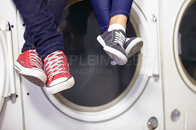 Buy stock photo Cropped image of a couple's feet as they sit on a washing machine at the laundromat