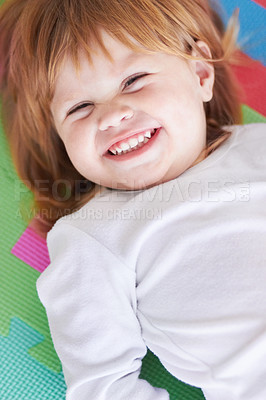 Buy stock photo Young girl, laughing and happiness portrait of a baby on a home playpen ground with a smile. Ginger infant, kid laugh and happy in a house with joy, youth and positivity from childhood looking up 