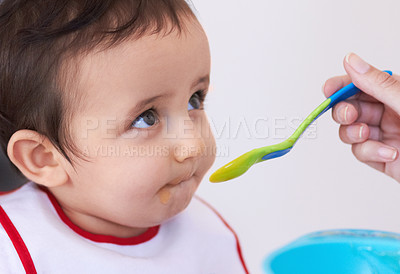 Buy stock photo A cute baby boy being fed by his mother's hand