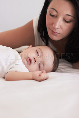 Buy stock photo A mother looking lovingly at her baby boy while he sleeps