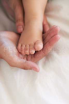 Buy stock photo Cropped image of a mother's hands holding her baby boy's foot