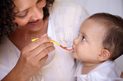 Buy stock photo A cute baby girl being fed by her mother