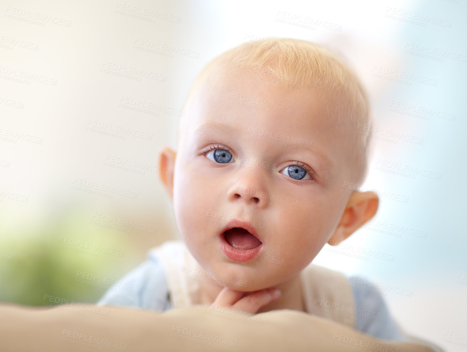 Buy stock photo Baby, portrait or mouth curious in home for childhood development, safety or growth health. Boy, hand or face or discover support for alert play or youth learning or protection, comfort care in house