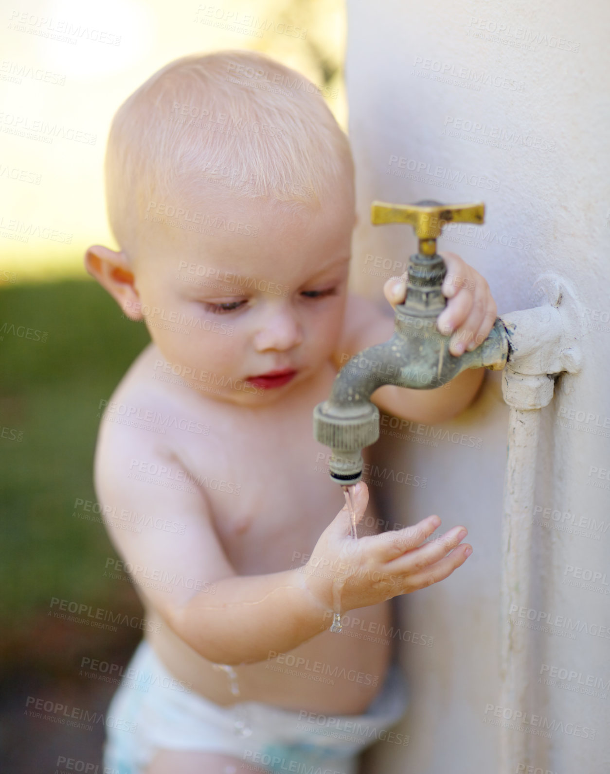 Buy stock photo Outdoor, water and a baby playing at a tap in a summer garden at home. Little kid, childhood growth and adorable infant boy curious about faucet, washing hands and getting wet in backyard of a house
