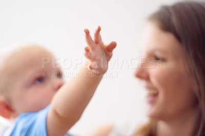Buy stock photo Happy, hand or mom blur with baby for love or bond together to nurture child development. Smile, play or single parent mother with a young newborn for trust, growth or safety in family house to relax