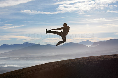 Buy stock photo A male kickboxer flying through the air as he practises his fly kick technique