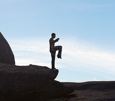 Buy stock photo A male kickboxer balancing on a cliff